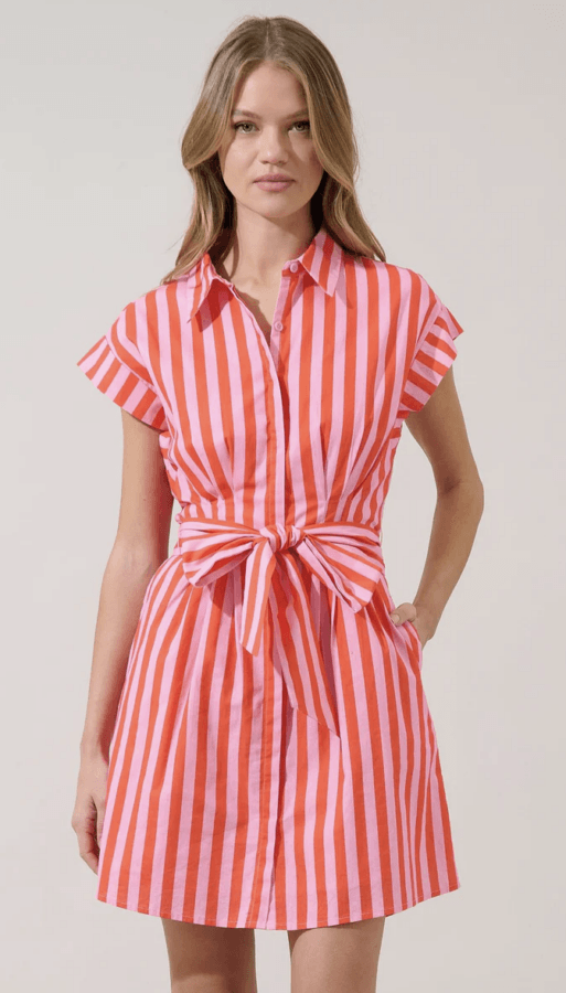 19 Fresh FINDS Around BHAM: Closet Refreshers, Entertaining Picks & More - 9 A woman wearing a short-sleeved, collared dress with vertical pink and red stripes and a front tie at the waist, standing against a plain background.