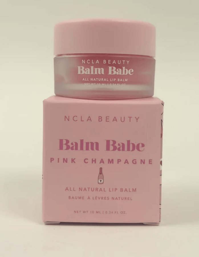 19 Fresh FINDS Around BHAM: Closet Refreshers, Entertaining Picks & More - 19 A small pink jar labeled "NCLA Beauty Balm Babe" sits on top of a matching pink box labeled "Pink Champagne All Natural Lip Balm"—a true fresh find perfect for beauty lovers in Birmingham.