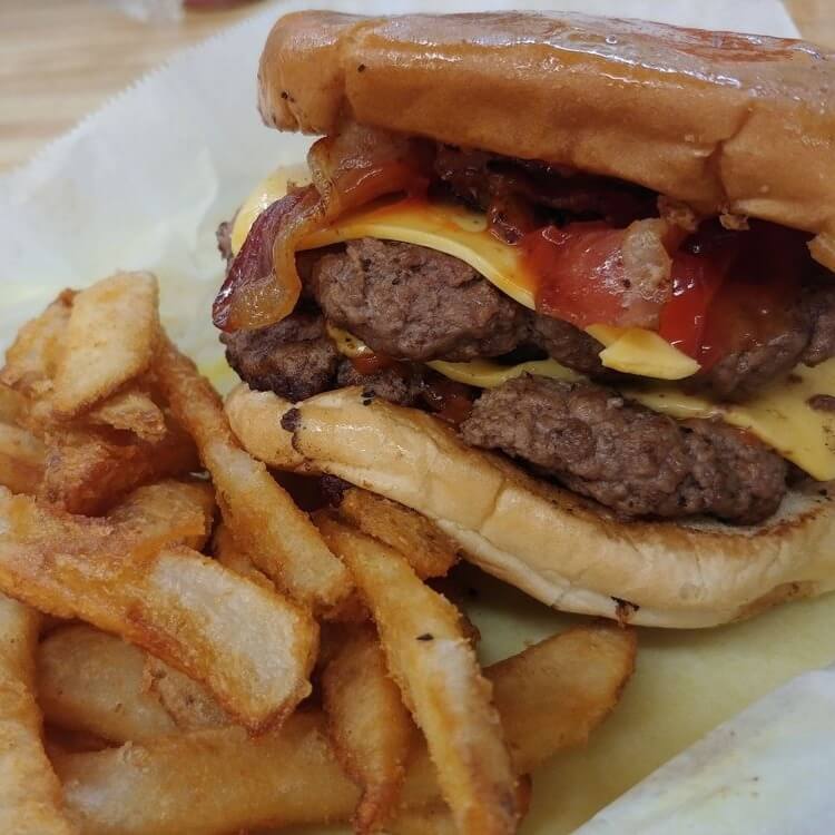 11 Must-Try Burgers in Birmingham - 5 A BHAM favorite, this cheeseburger features two beef patties and crispy bacon on a bun, served with thick-cut French fries at J&J Grocery and Deli.