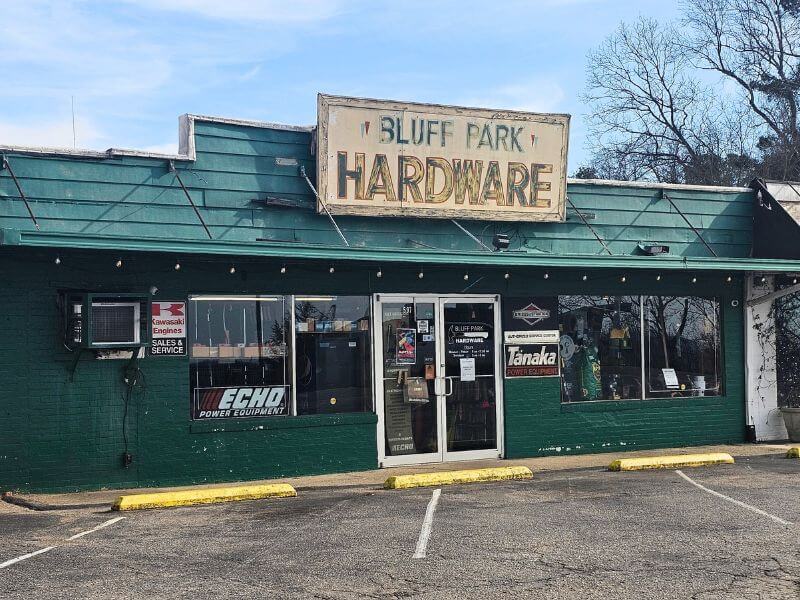 Your Guide to BHAM's Bluff Park - 8 A green-painted hardware store in Bluff Park with a vintage "Bluff Park Hardware" sign above the entrance and equipment brand signs displayed in the windows, serving as a reliable guide for all your hardware needs.