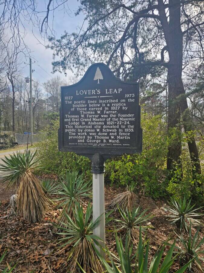 Your Guide to BHAM's Bluff Park - 10 Historical marker for Lover's Leap in Bluff Park, Birmingham, Alabama, describing its inscription, founder Thomas W. Farrar, and donation by the Masonic Trust in 1935. Trees and road are visible behind this notable guide to local history.