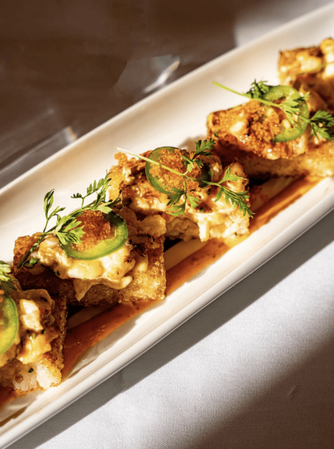 10 New Birmingham Restaurants to Try This Month - 6 A rectangular plate with pieces of crispy sushi rice topped with spicy mayo, sliced jalapeño, herbs, and a drizzle of sauce.