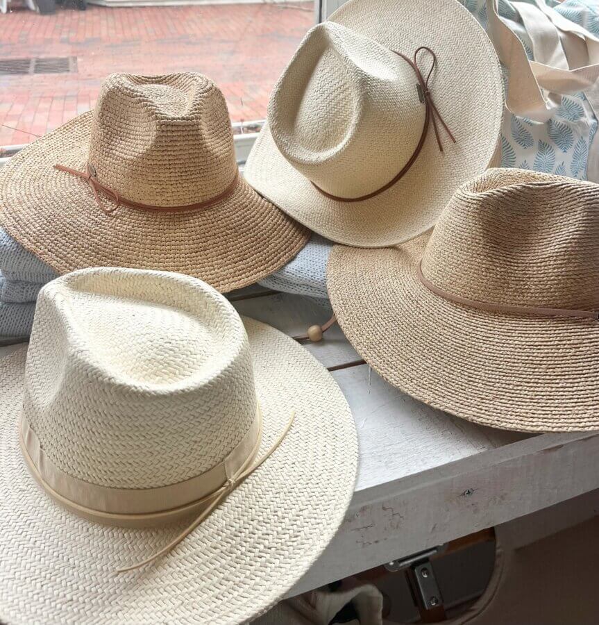 18 Nashville FINDS We're Loving This Month - 7 Four straw hats with different bands and brim shapes are laid out on a white surface near a window, with a tote bag in the background—a perfect FINDS Draft for your March 2026 style inspiration.
