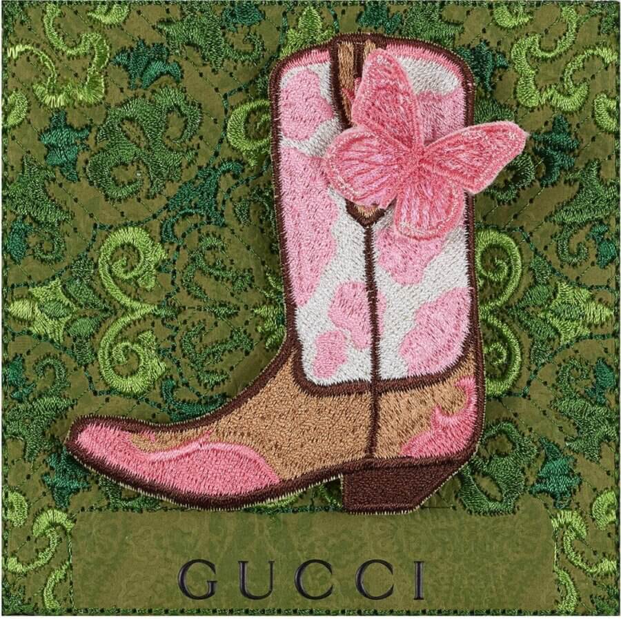 18 Nashville FINDS We're Loving This Month - 19 Embroidered patch of a pink and brown cowboy boot with a pink butterfly, set on a green, ornate textured background with "GUCCI" at the bottom. A standout piece from the FINDS Draft, March 2026 collection.