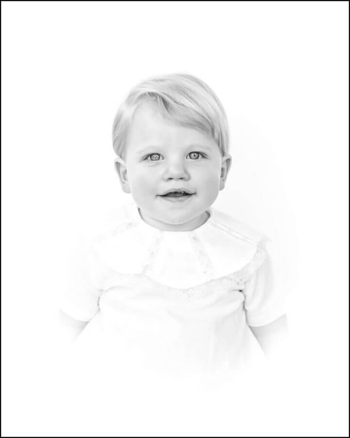 Heirloom Portraits Are Making a Comeback! - 2 Black and white portrait by Southern Heirloom Portrait Photographers of a young child with light hair, wearing a dress with a lace collar, looking directly at the camera against a white background.