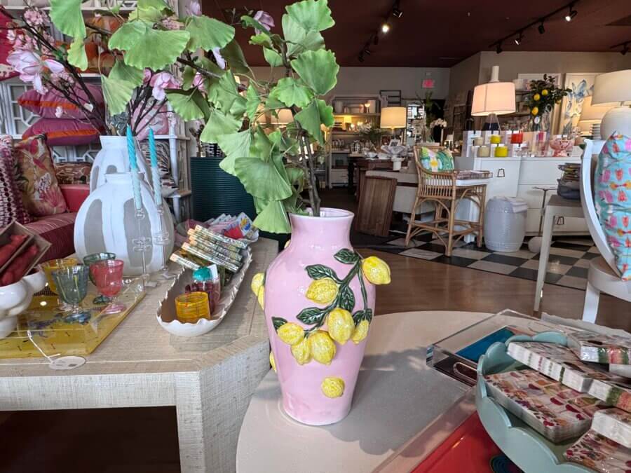 16 Louisville FINDS for April: Spring Style, Derby-Ready Decor & Must-Have Gifts - 10 A pink vase decorated with yellow lemons sits on a display table in a brightly lit, colorful Louisville shopping destination—perfect for spring finds.