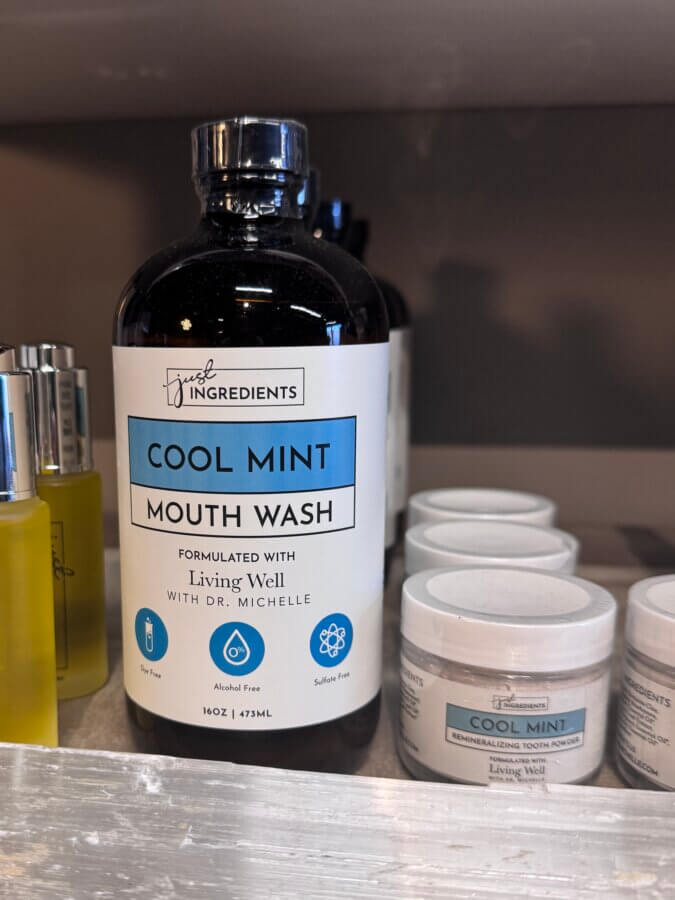 16 Louisville FINDS for April: Spring Style, Derby-Ready Decor & Must-Have Gifts - 17 A bottle of Cool Mint Mouth Wash by Just Ingredients sits on a shelf next to smaller bottles and containers of remineralizing tooth powder—an ideal Spring refresh, spotted among Louisville Finds.