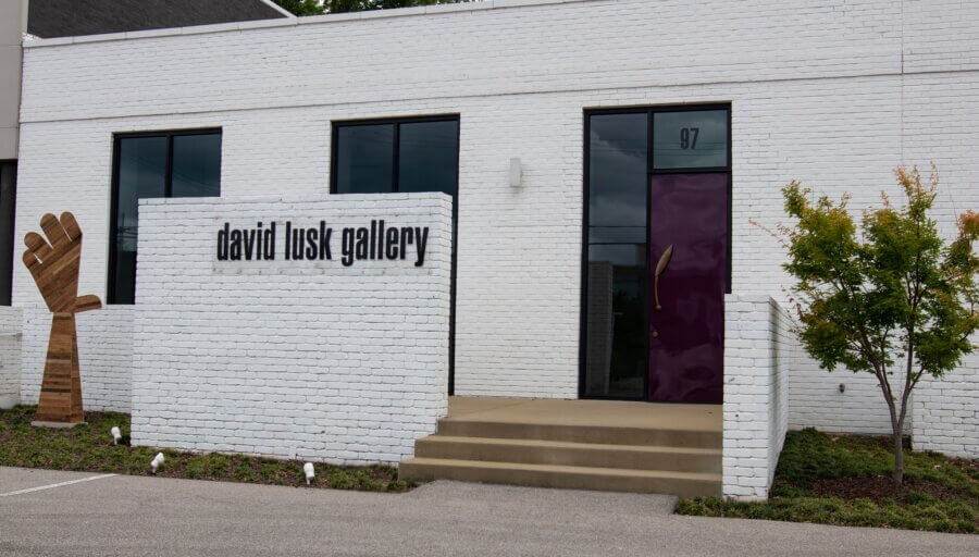 7 Memphis Galleries Exhibiting at Art by Design 2026 - 8 Exterior view of the David Lusk Gallery—one of the standout Memphis galleries—features a white brick facade, large sign, steps to a purple door, and a small tree beside the entrance. Ideal for discovering the upcoming Art by Design 2026 art exhibition.