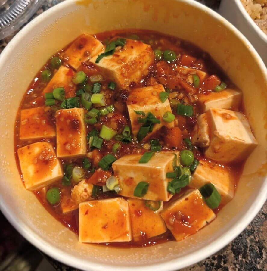 5 New Memphis Restaurants to Try This Month (+ What's Coming Soon!) - 8 A bowl of mapo tofu with cubed tofu in a spicy red sauce, topped with chopped green onions.