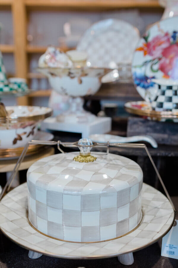 15 Memphis FINDS at Local Shops: Spring Dresses, Home Decor & More! - 14 A ceramic cake stand with a white and beige checkered pattern and a glass knob on top, featured among other decorative dishwareβa charming Memphis FINDS March highlight.