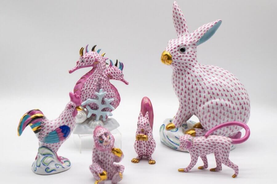 Nashville Steals, Deals & Announcements: April 2026 - 3 A group of porcelain animal figurines, including a rabbit, seahorse, rooster, monkey, and squirrels, all with a pink fishnet pattern, gold accents, blue details on a white background.