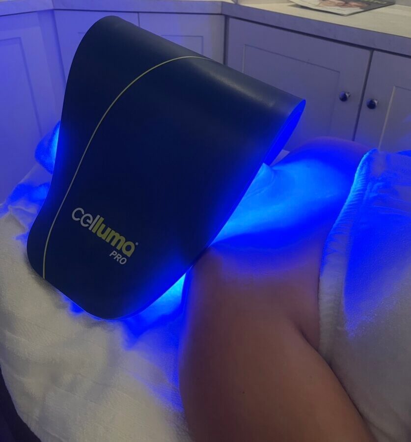 Nashville Steals, Deals & Announcements: April 2026 - 4 A person is receiving light therapy on their hip with a Celluma Pro device emitting blue light while lying on a treatment table—spotlighting one of the latest Nashville deals in self-care treatments.