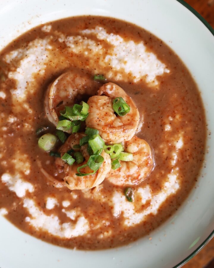 Your Updated Guide to The Gulch, One of Nashville's Most Bustling Neighborhoods - 3 A bowl of shrimp and grits topped with sliced green onions, served with a savory brown sauceโa signature Southern dish inspired by the flavors of The Gulch.