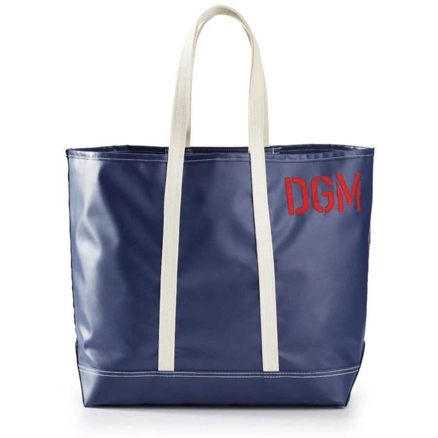 A blue tote bag with cream-colored handles and "DGM" embroidered in red on the upper right corner, perfect for carrying your essentials alongside your chic rainwear during April showers.