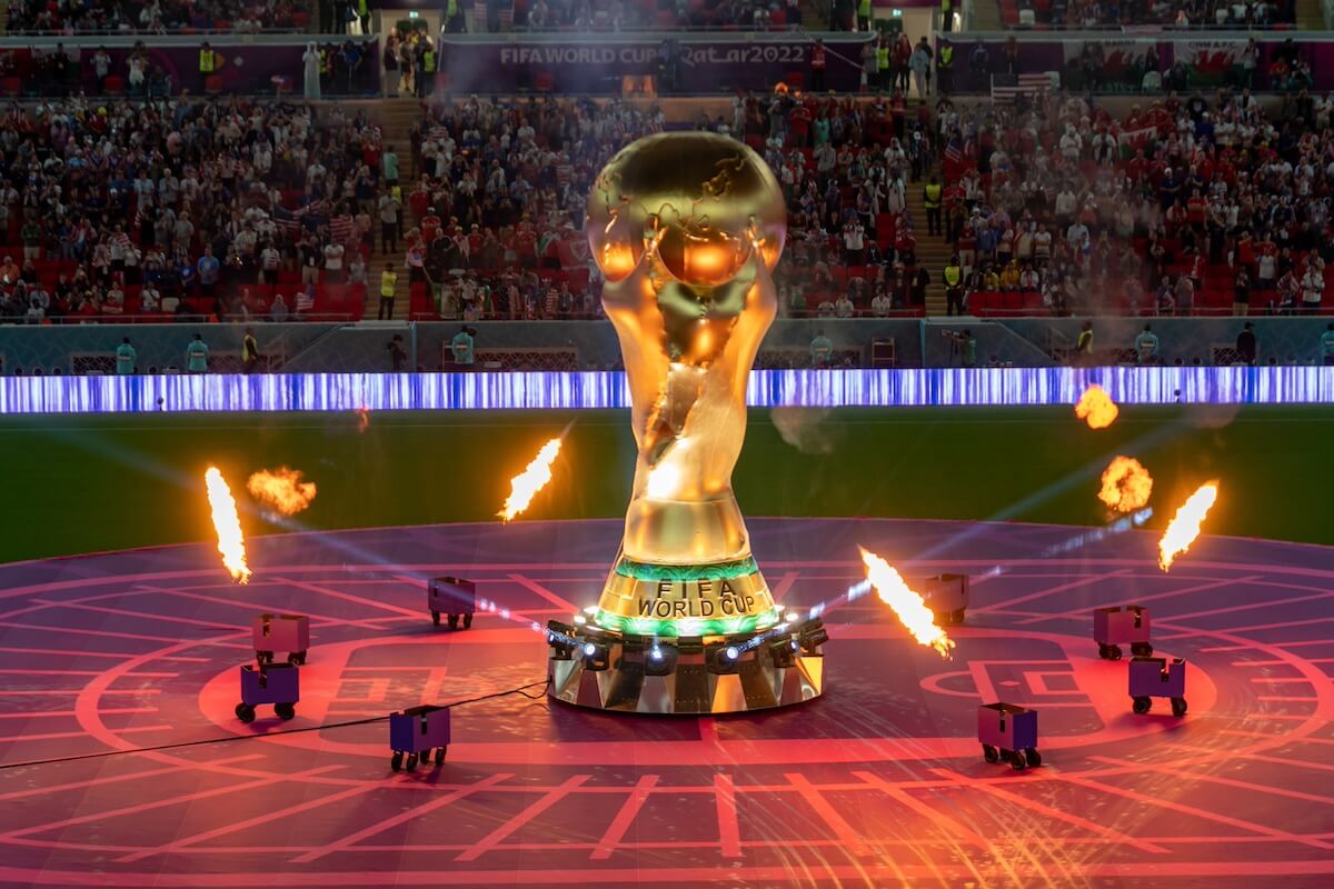 A large replica of the FIFA World Cup trophy is displayed on the field with flames and lights during an event at a stadium, capturing the excitement found in any true Southerner's Guide to the World Cup.