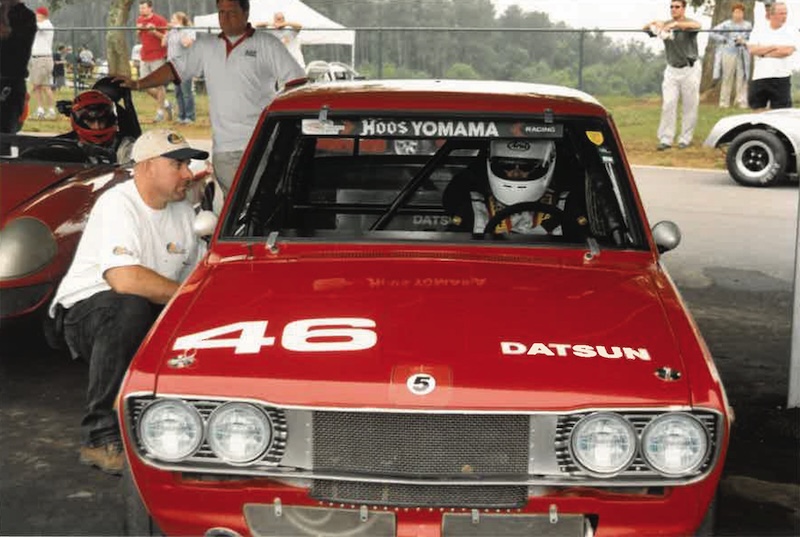 Meet Virginia Raceway Queen Connie Nyholm - 3 A red Datsun race car with the number 46 is parked as a person in racing gear sits inside.