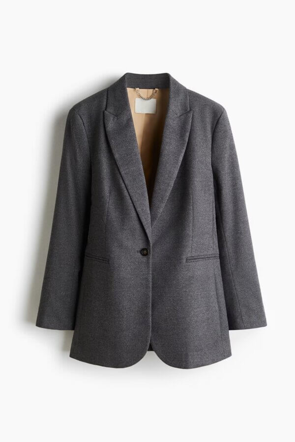 It's the Year of the Brooch! Here's How to Style Them - 2 A single-breasted, dark gray women's blazer with a notched lapel and one button, perfect for adding your favorite brooch or celebrating the Year Of The Brooch, hanging on a white background.