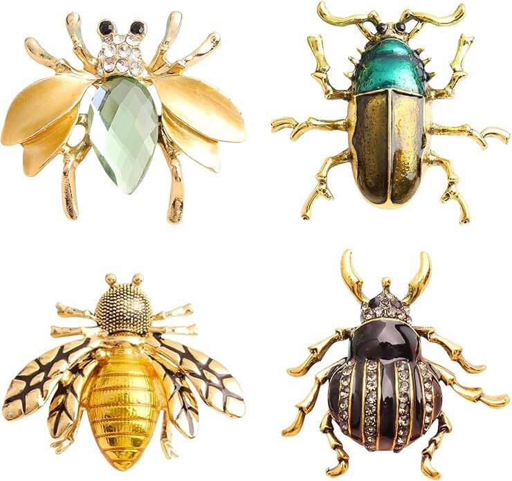 It's the Year of the Brooch! Here's How to Style Them - 14 Four decorative insect-shaped brooches are shown, each with unique metallic and jeweled details resembling bees and beetles, arranged in a two-by-two gridβa striking showcase for the Year Of The Brooch.
