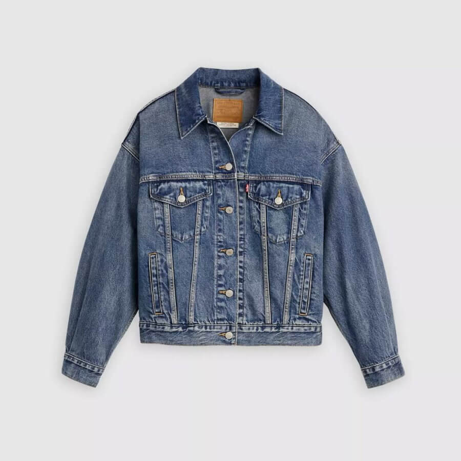 It's the Year of the Brooch! Here's How to Style Them - 9 Blue denim jacket with button front, two chest pockets with flaps and buttons, and visible tan stitching, perfect for showcasing your favorite Year Of The Brooch accessories, displayed on a plain light background.