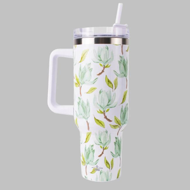 18 Birmingham FINDS for May Celebrations: Graduation, Mother's Day & More - 19 A tall white FINDS tumbler with a handle and straw, featuring a green and yellow leaf pattern, stands out against a plain grey background—perfect for your May adventures in Birmingham.
