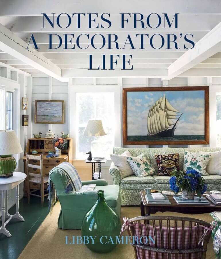 9 New Design-Forward Coffee Table Books for Your Wish List - 5 Living room with nautical decor, green sofa, patterned chairs, wooden coffee table book, books, nautical artwork, and large green glass bottle; perfect for design envy. Book title and author text overlayed.