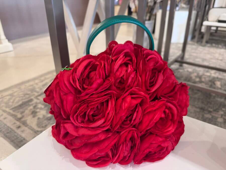 16 Louisville FINDS for April: Spring Style, Derby-Ready Decor & Must-Have Gifts - 3 A spring-inspired handbag designed to look like a cluster of red roses with a green handle, displayed indoors on a white surface—a unique Louisville FINDS accessory.