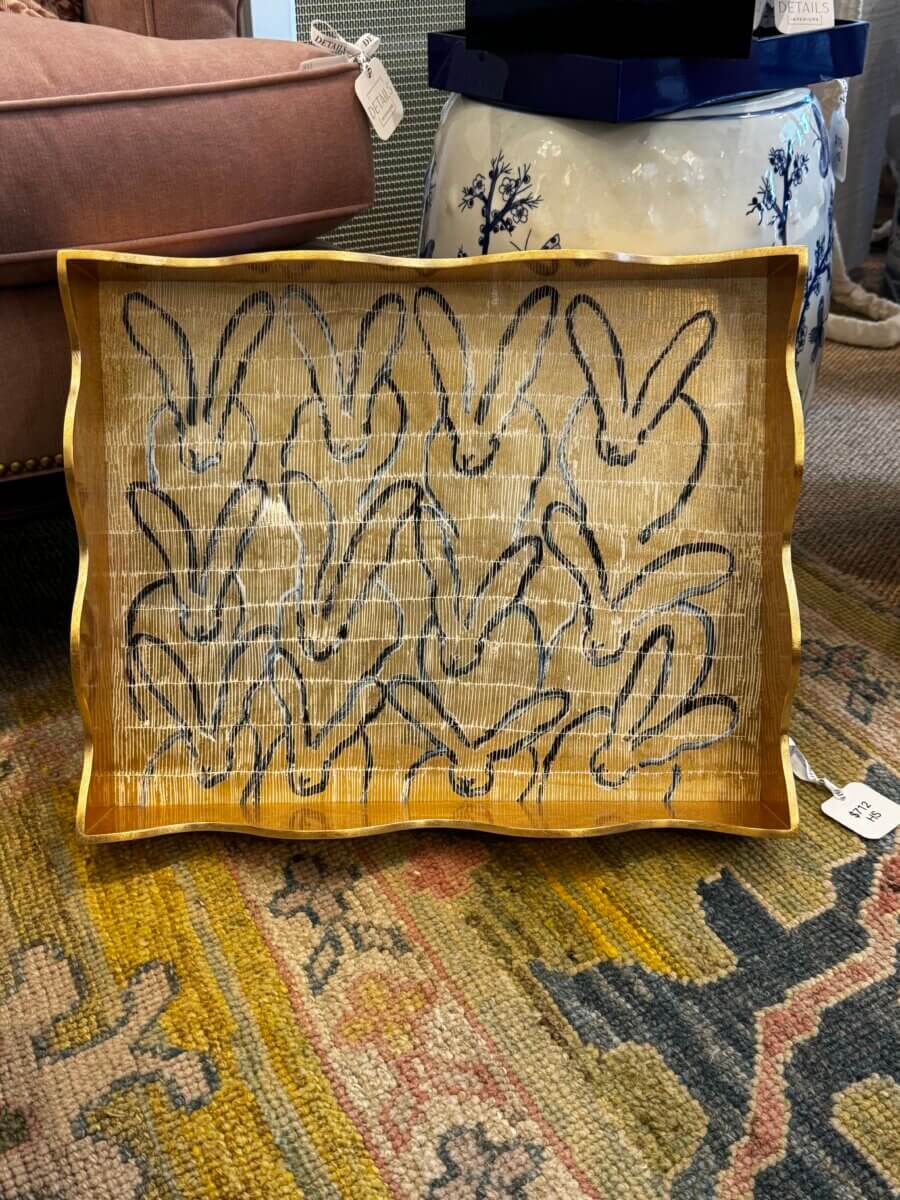 15 Louisville FINDS for May: Spring Fashion, Entertaining Essentials & More - 9 A wooden tray with a wavy edge features a pattern of outlined rabbit heads on its surfaceβone of Mayβs cutest FINDS in Louisvilleβplaced on a patterned rug near upholstered furniture.