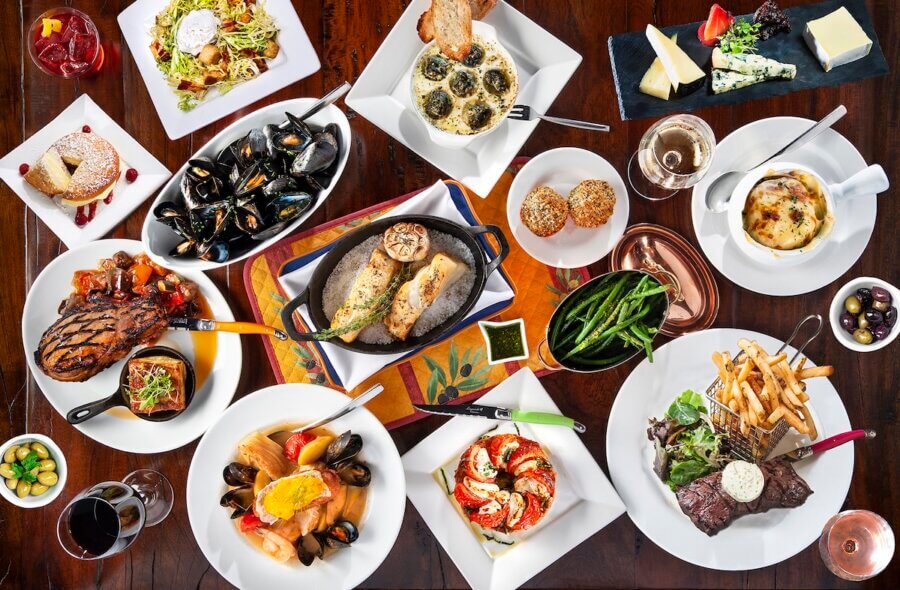 All-Ages Adventure: The Ultimate Trip to Louisville, KY - 8 A culinary adventure awaits in Louisville, with French dishes like steak, mussels, escargot, green beans, cheese, bread, and desserts beautifully arranged on a wooden table for all-ages to enjoy.