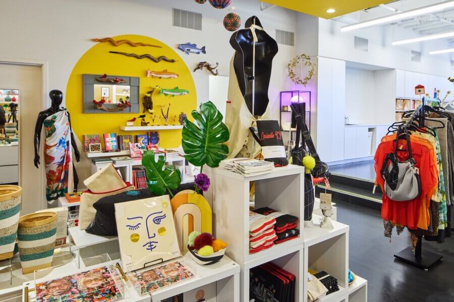 All-Ages Adventure: The Ultimate Trip to Louisville, KY - 12 Colorful boutique store interior in Louisville, displaying art prints, jewelry, textiles, home decor, and accessories on shelves, racks, and mannequins against a yellow accent wall—an all-ages adventure in creativity and style.