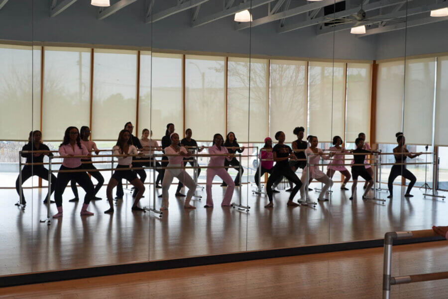 Meet the Creative Force Behind Soul88 & Civic Change in Memphis - 7 A group of people participate in a FACES barre class, exercising at ballet barres in a mirrored studio with wooden floors and large windows.