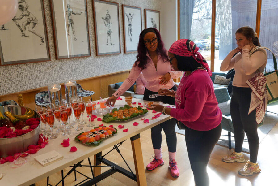Meet the Creative Force Behind Soul88 & Civic Change in Memphis - 5 Courtney McNeal and another woman serve themselves sushi and drinks from a decorated table at an indoor event, while a third woman stands nearby holding a tote bag.