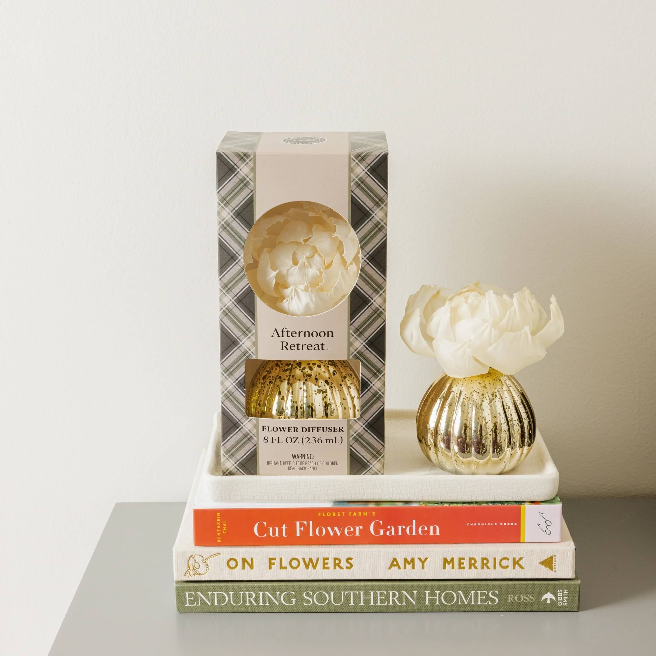 15 Memphis FINDS for May: Mother's Day & Spring Celebrations - 14 A flower diffuser with packaging sits on a white tray atop three stacked books—"Cut Flower Garden," "On Flowers," and "Enduring Southern Homes"—a charming scene perfect for those who love Memphis shopping and elegant home accents.