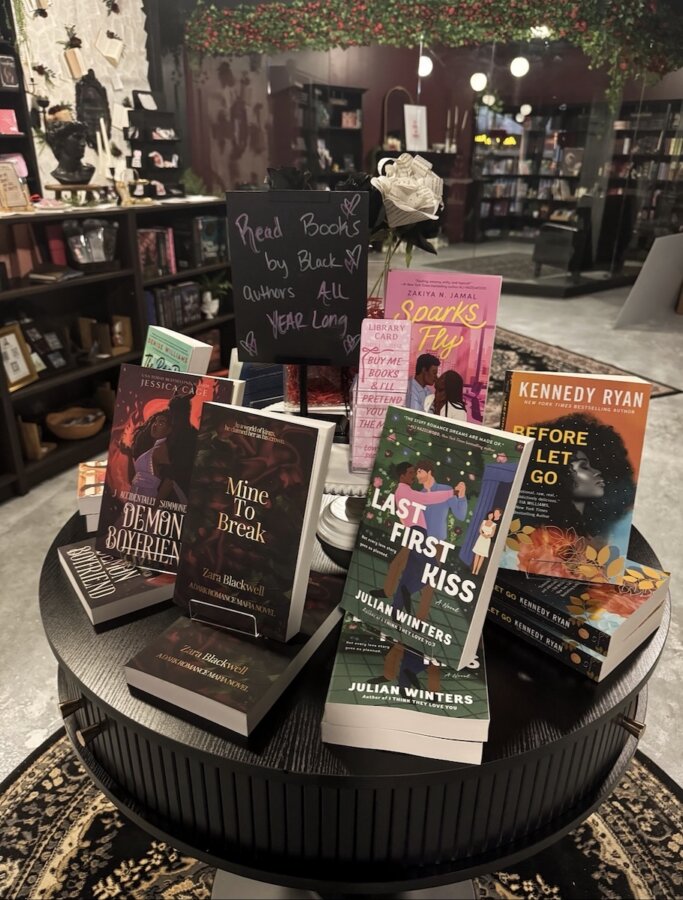 She's Behind Nashville’s First Romance-Only Bookstore - 5 A round table display in a Nashville romance bookstore features books by Black authors, with a chalkboard sign encouraging readers to read these books all year long.