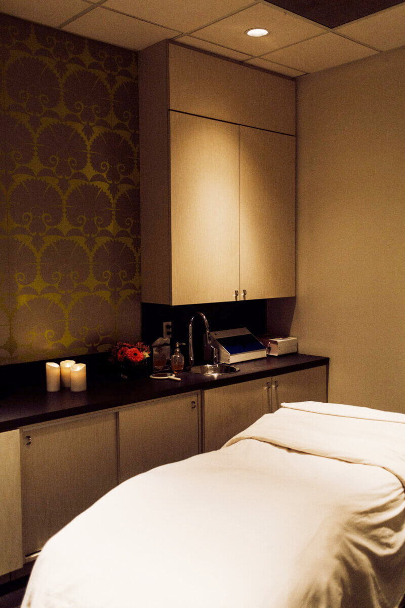 Nashville Steals, Deals & Announcements: May 2026 - 7 Experience relaxation in a spa treatment room with a massage table, soft lighting, lit candles, and a patterned accent wall—perfect for enjoying exclusive Nashville Deals in May 2026.