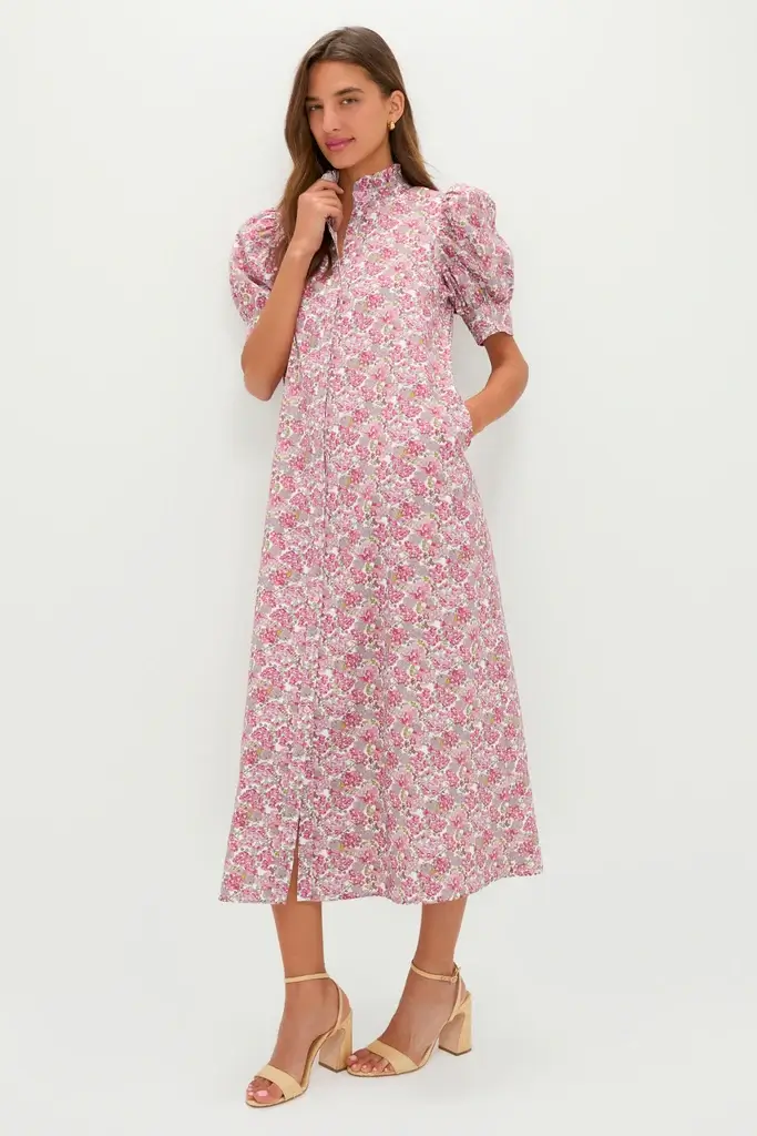 4 Easy, Breezy Fashion Trends for Summer 2026 - 9 A woman wears a light pink floral midi dress with puffed short sleeves and beige heeled sandals, standing against a plain white background—an effortless nod to 2026 Summer Trends.