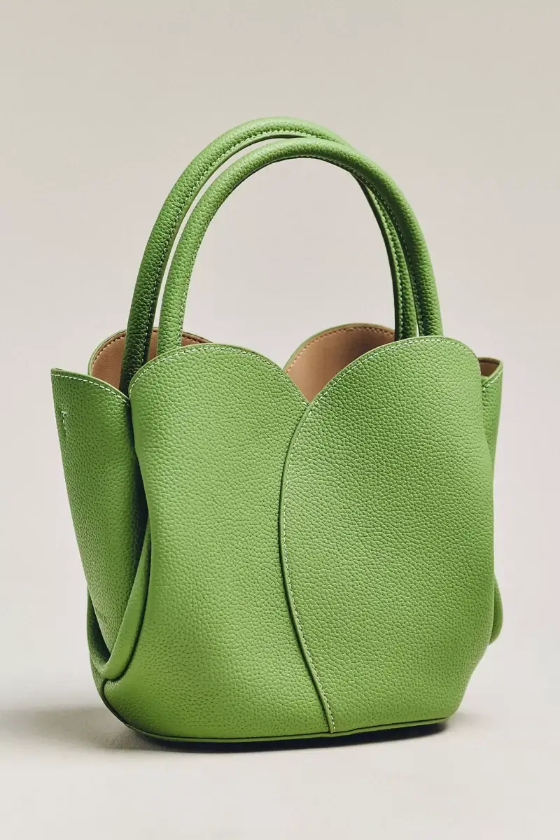 4 Easy, Breezy Fashion Trends for Summer 2026 - 14 A small, structured green handbag with double handles and a textured leather finish.