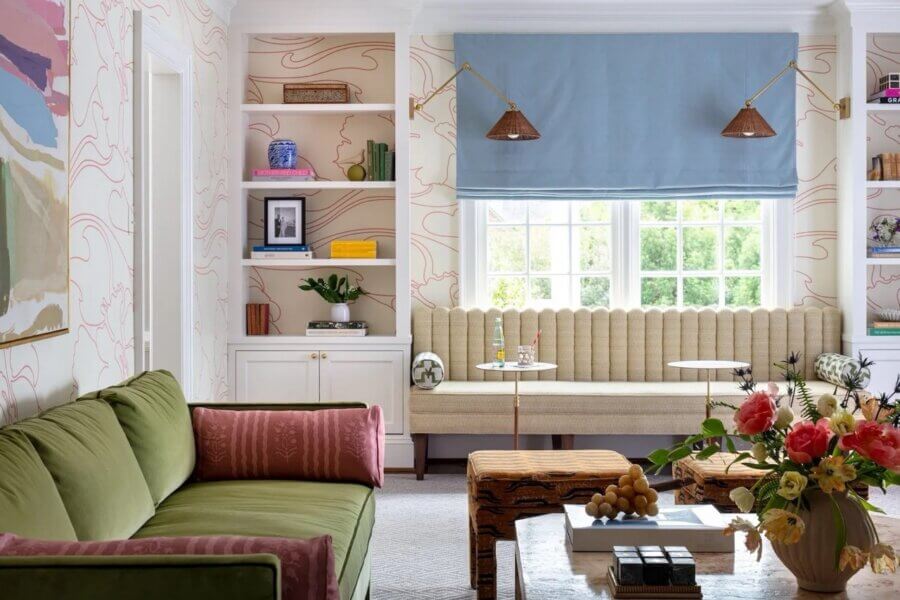 It Started with Wallpaper: Look Inside This Reimagined Richmond Colonial - 3 A living room with a green sofa, a built-in window bench with a blue shade, shelves with decor, and a coffee table topped with flowers and fruit—perfect for a colorful Richmond home.