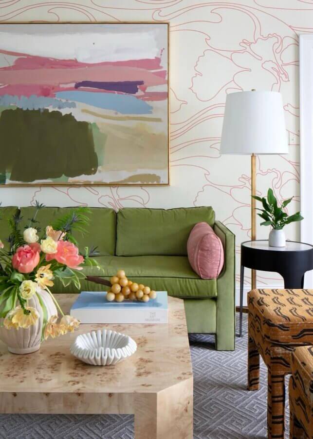 It Started with Wallpaper: Look Inside This Reimagined Richmond Colonial - 4 A living room with a green sofa, classic Thibaut Wallpaper, abstract wall art, floral arrangement, beige coffee table, gold floor lamp, and a small side table with a plant.