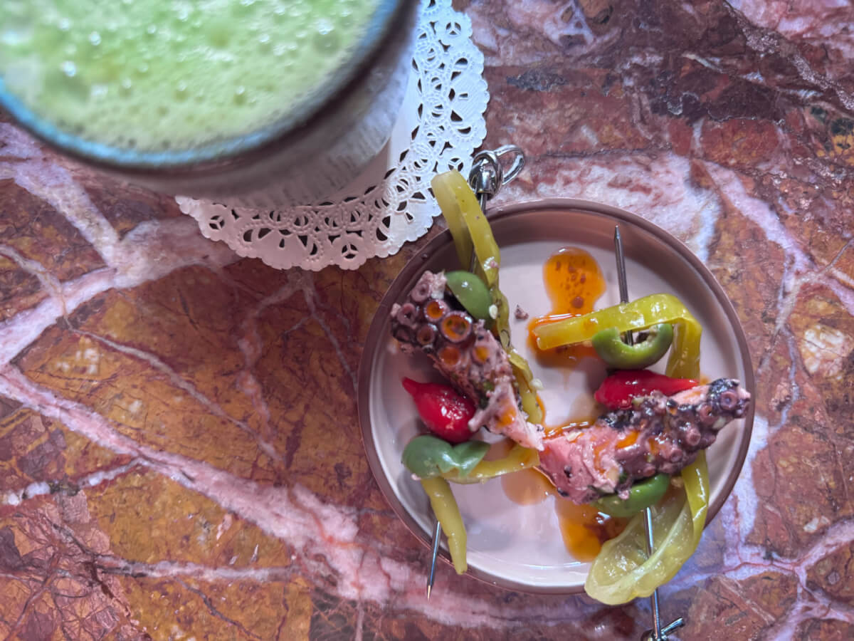 11 New Nashville Restaurants to Try This Month - 3 A small plate of octopus on skewers, next to a green drink.