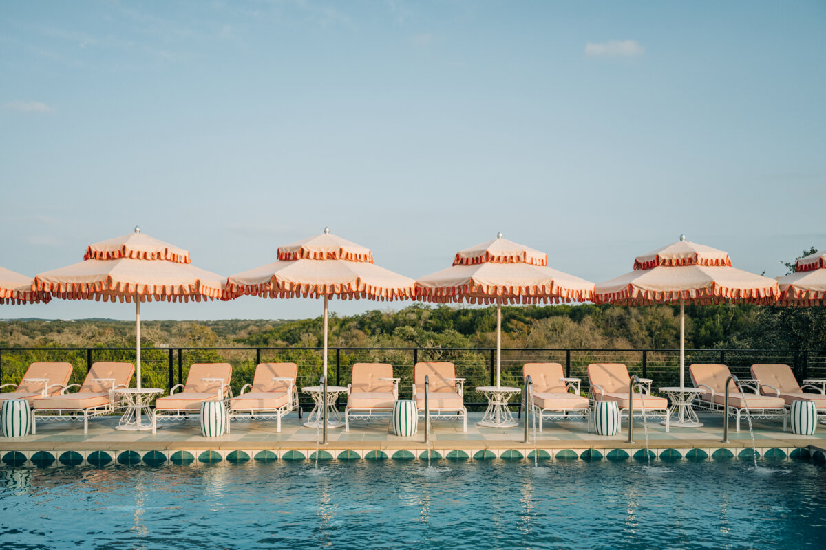 She's Behind Camp Lucy, a Dreamy Austin-Area Escape - 12 Umbrellas and lounge chairs by the pool at Camp Lucy.