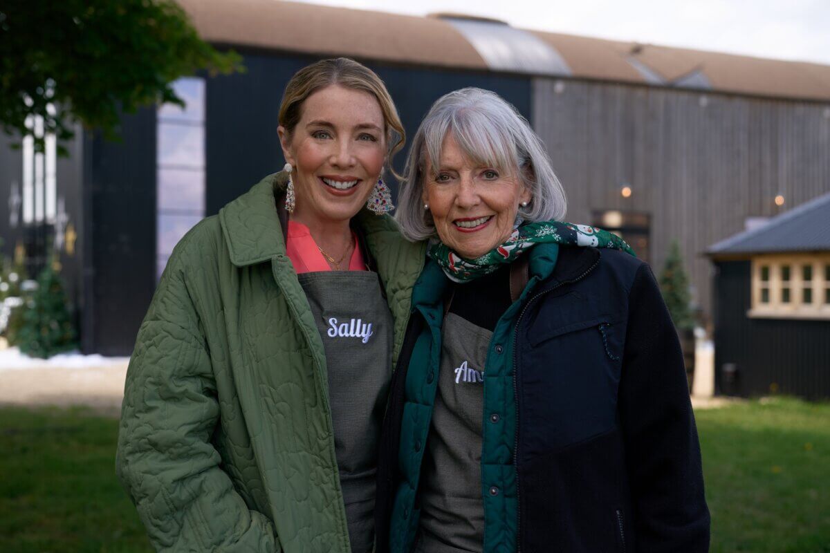 Meet Sally McKay, the Founder of Sally's Confections - 5 Sally Wicker McKay and Amy Moree Wicker stand outside a barn-like building, wearing aprons labeled "Sally" and "Ann."