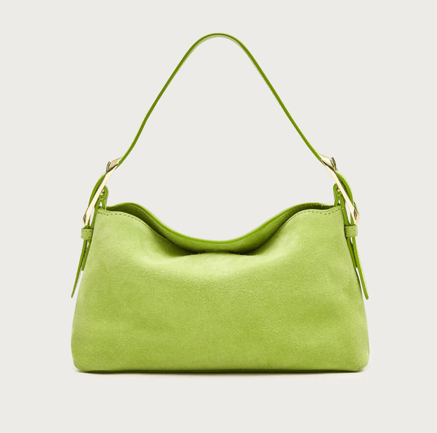 A small, lime green suede handbag with a single shoulder strap and gold hardware, this stylish accessory stands out among colorful bags, photographed against a plain light background.