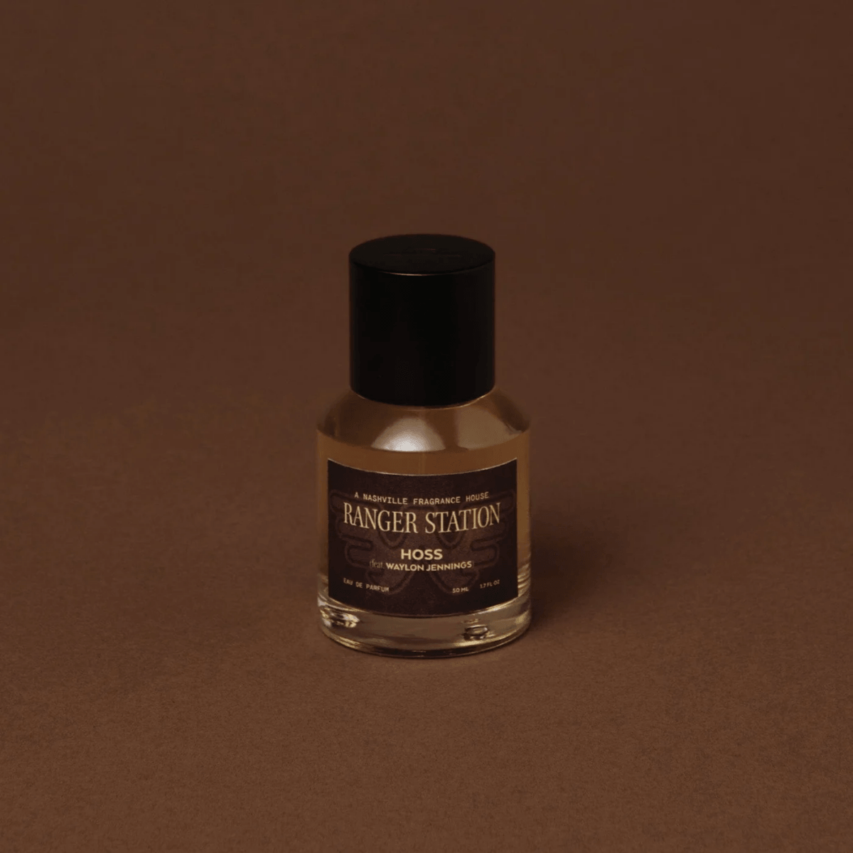 20 Nashville FINDS for June: Father's Day Gifts, Chic Accessories & More - 21 A clear glass bottle of Ranger Station Hoss fragrance with a black cap, set against a plain brown background—one of our favorite Nashville FINDS this May.