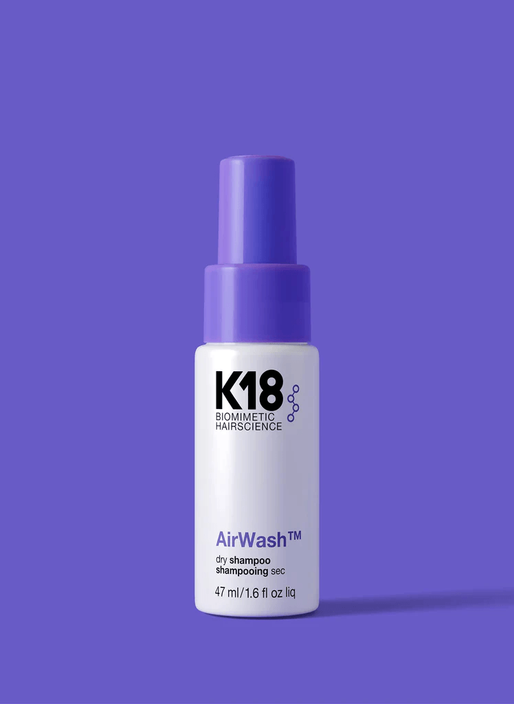 20 Nashville FINDS for June: Father's Day Gifts, Chic Accessories & More - 13 A bottle of K18 AirWash dry shampoo with a purple pump cap, shown against a solid purple background—a fresh Nashville FINDS discovery for May.