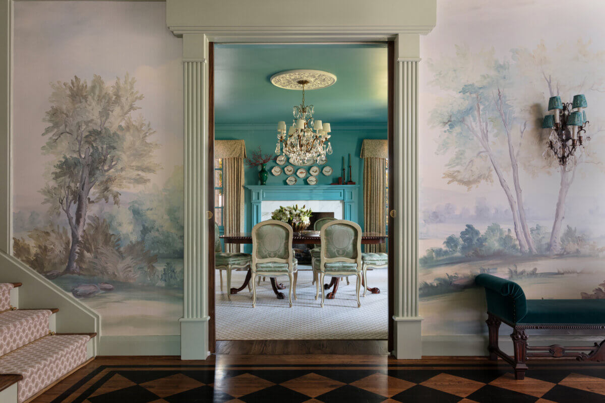 In the foreground, a wallpaper mural surrounds an entryway. In the distance, there's a dining room table and fireplace.
