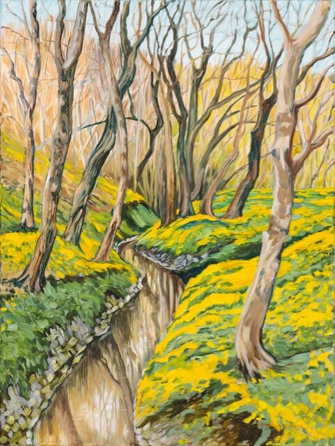Your Updated Guide to Butchertown - 7 A creek winds through Butchertown’s forest, where leafless trees stand tall and bright yellow flowers cover the grassy banks under a clear sky—a scene straight out of an updated guide to nature’s quiet beauty.