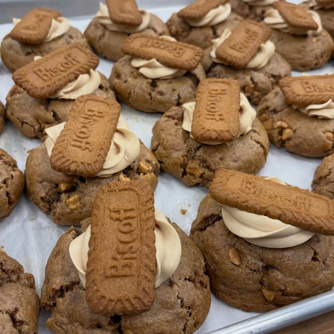She Didn't Get into Law School. So, She Built a Cookie Empire Instead. - 5 A tray of cookies from Bae's Baekery, each topped with a swirl of cream and a Biscoff biscuit, arranged in neat rows on parchment paper.