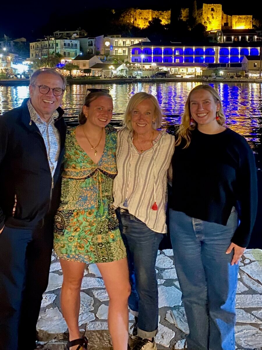 Meet Kirby Adams, the Lifestyle Reporter with a Story of Her Own - 7 Four people, including lifestyle reporter Kirby Adams, stand together smiling at night by a waterfront, with illuminated buildings and their reflections creating a picture-perfect setting.