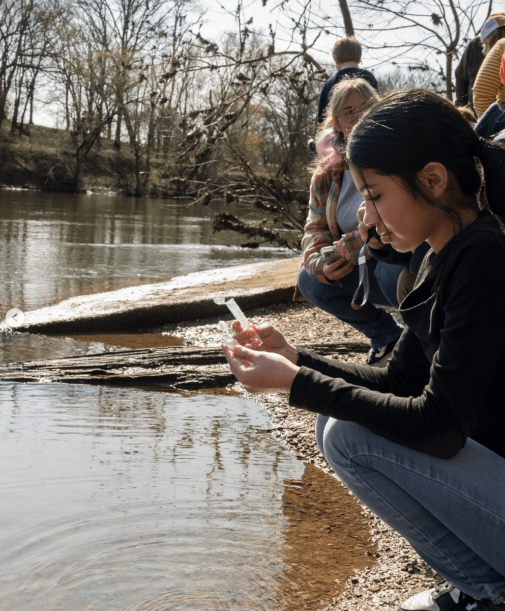 6 Ways to Get on the Water in Memphis - 4 A girl views a test tube by a river, where she's collecting water samples.