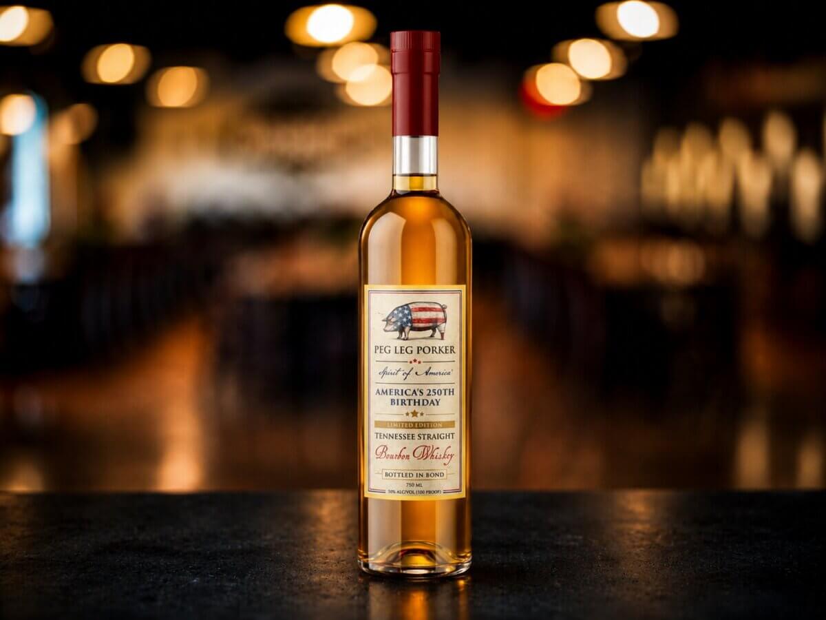 Nashville Steals, Deals & Announcements: June 2026 - 7 A bottle of Peg Leg Porker Tennessee Straight Bourbon Whiskey stands on a dark surface with a blurred background of warm lights.